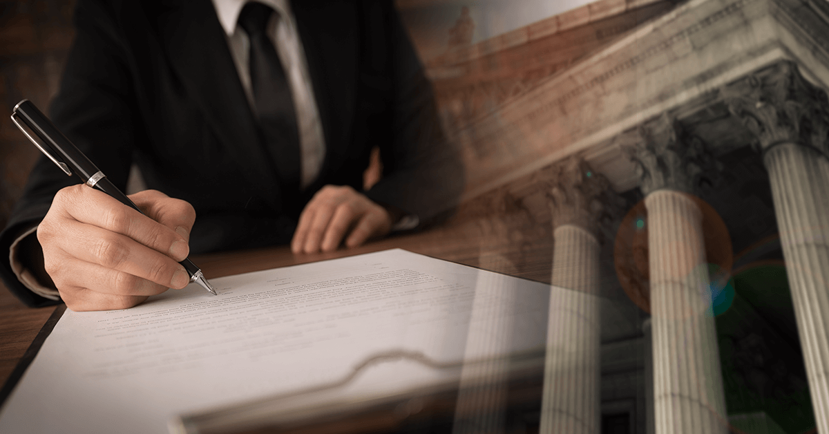 Lawyer signing legal document and agreement with court background